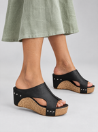 Severine sandals in black, worn with a sage green linen dress