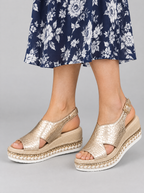 Tove sandals in gold, worn with a navy and white floral dress