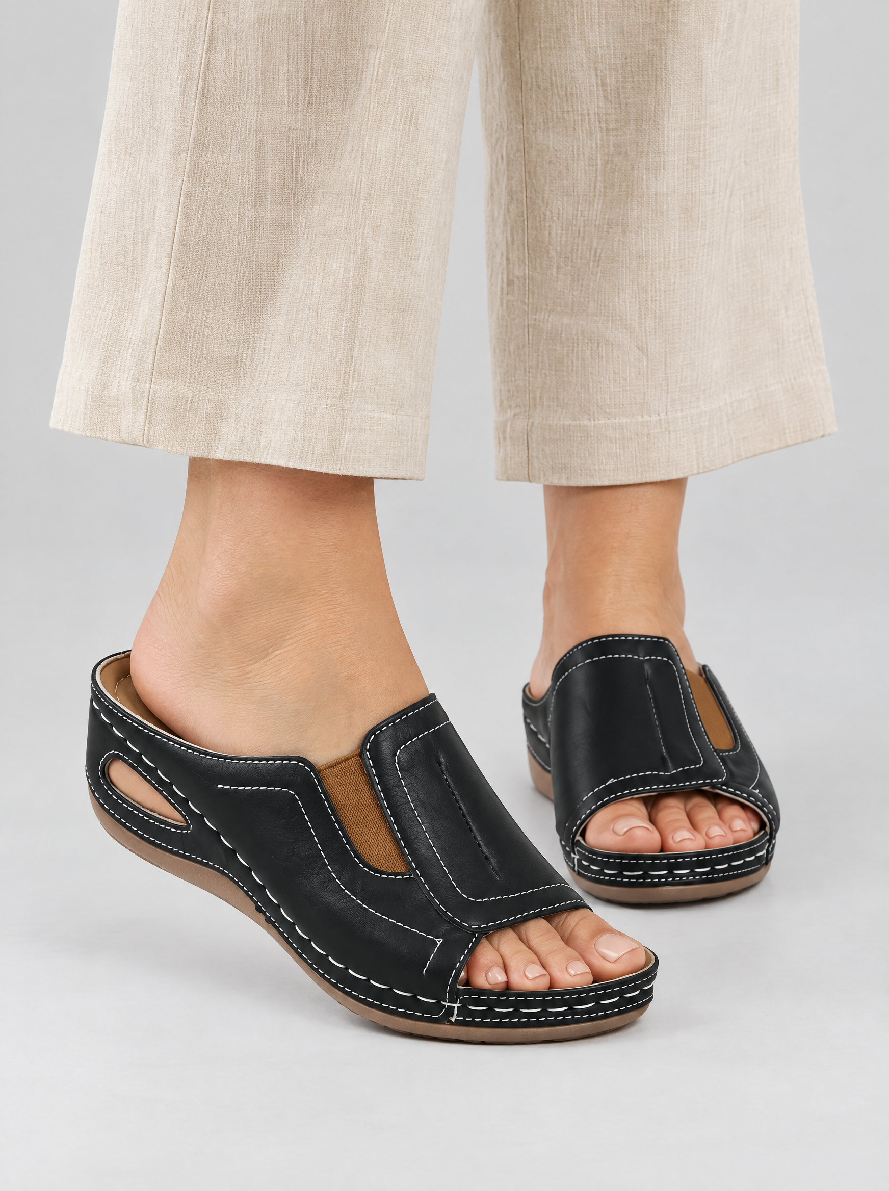 Tessa sandals in black, worn with beige linen trousers