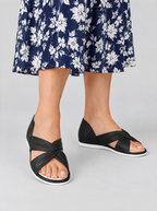 Delta sandals in black, worn with a navy and white floral dress