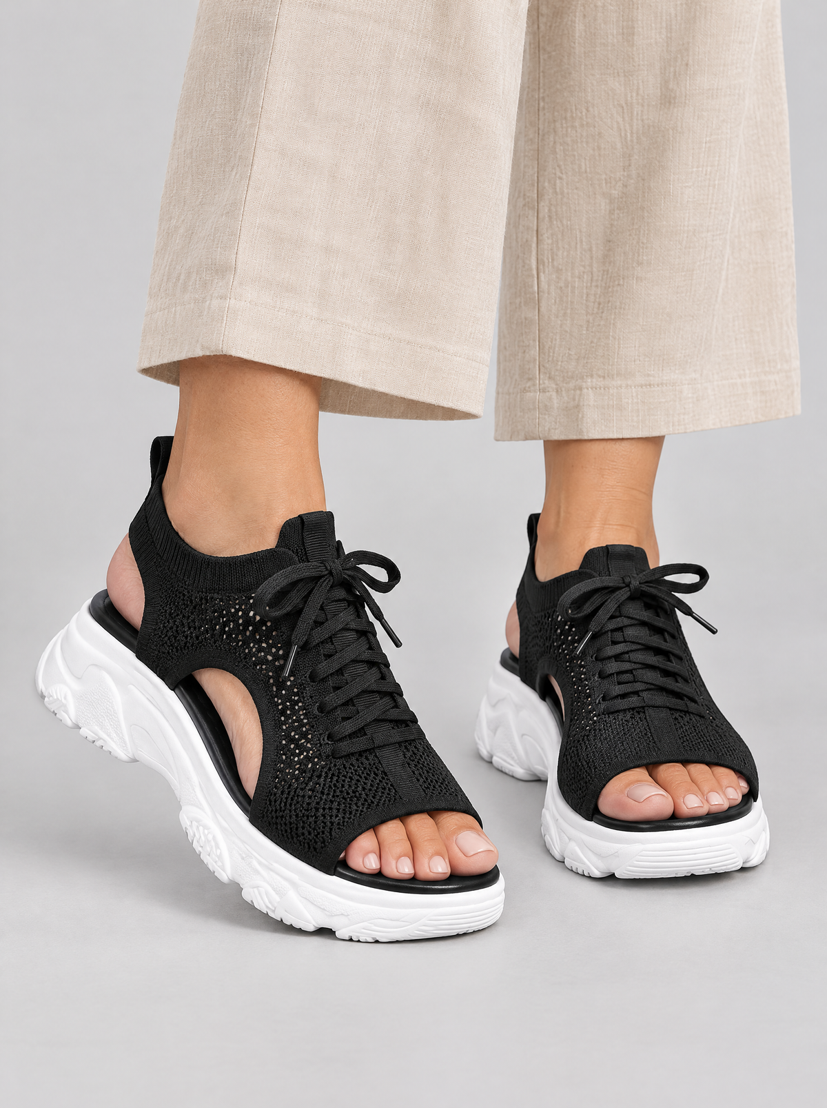 Signe sandals in black, worn with beige linen trousers